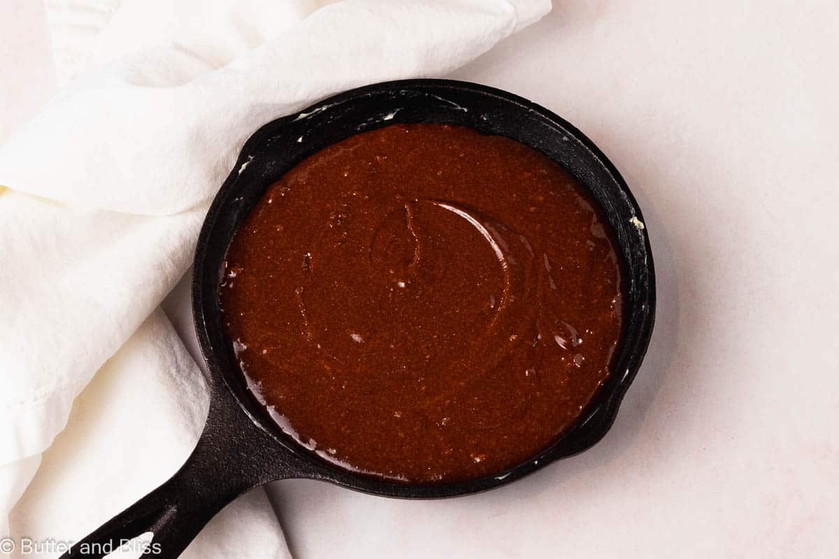 Fudgy brownie batter in a mini cast iron skillet ready to be baked.