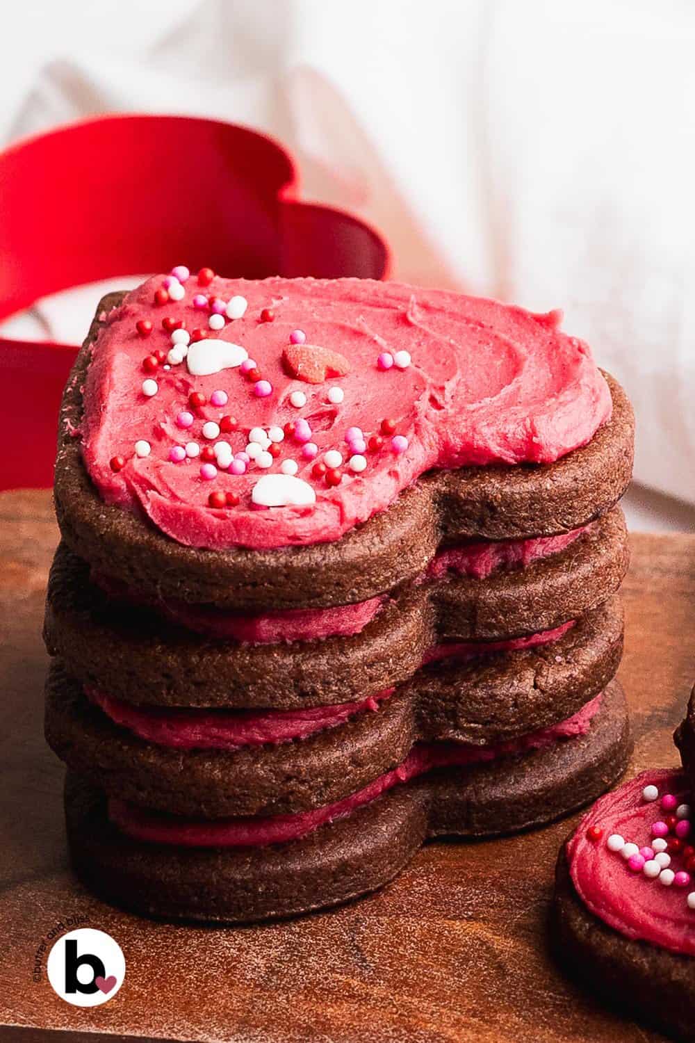 Stack of chocolate sugar cookies decorated with fruit-flavored cookie frosting.