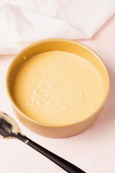 Vanilla cake batter in a cake pan ready to be baked.
