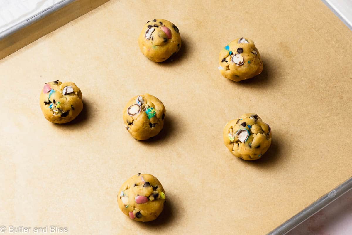 Cookie dough balls on a baking sheet ready to be baked.