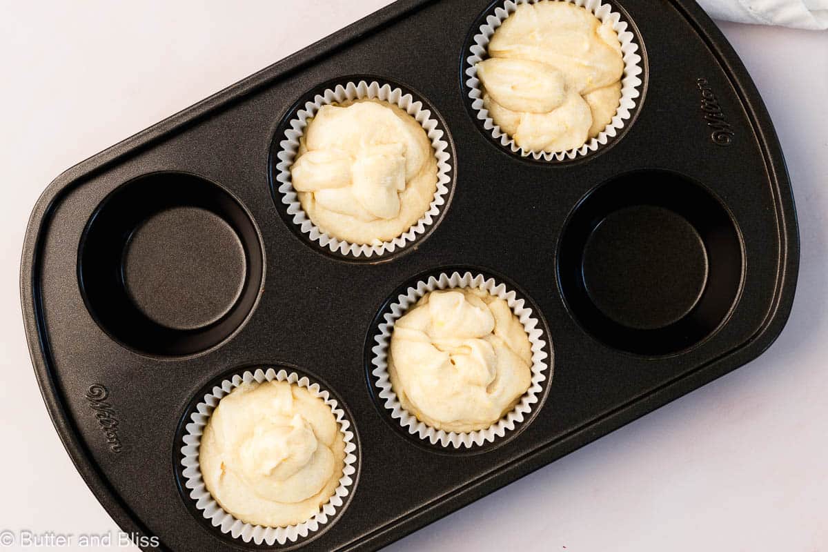 Lemon cupcake batter portioned into a cupcake pan ready to be baked.