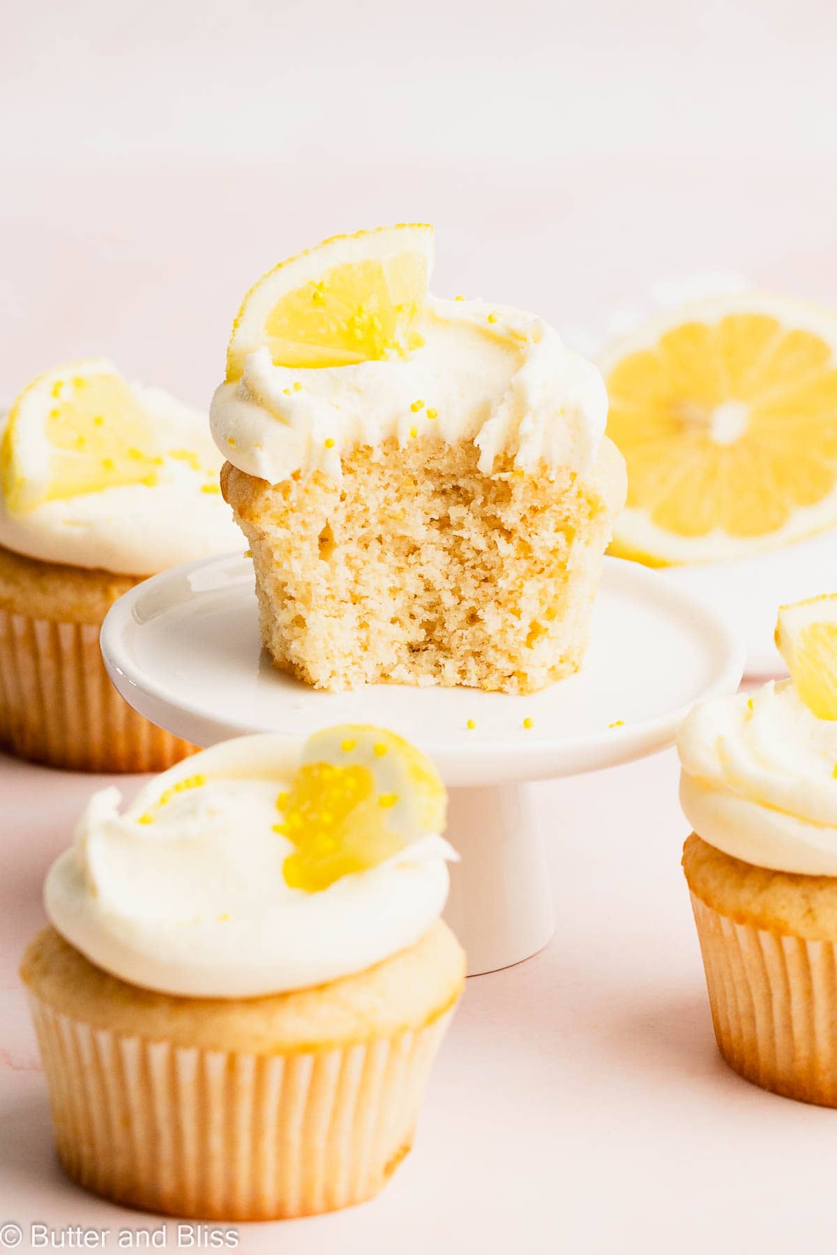 Lemon frosting on top of a fluffy cupcake on a mini cupcake stand.