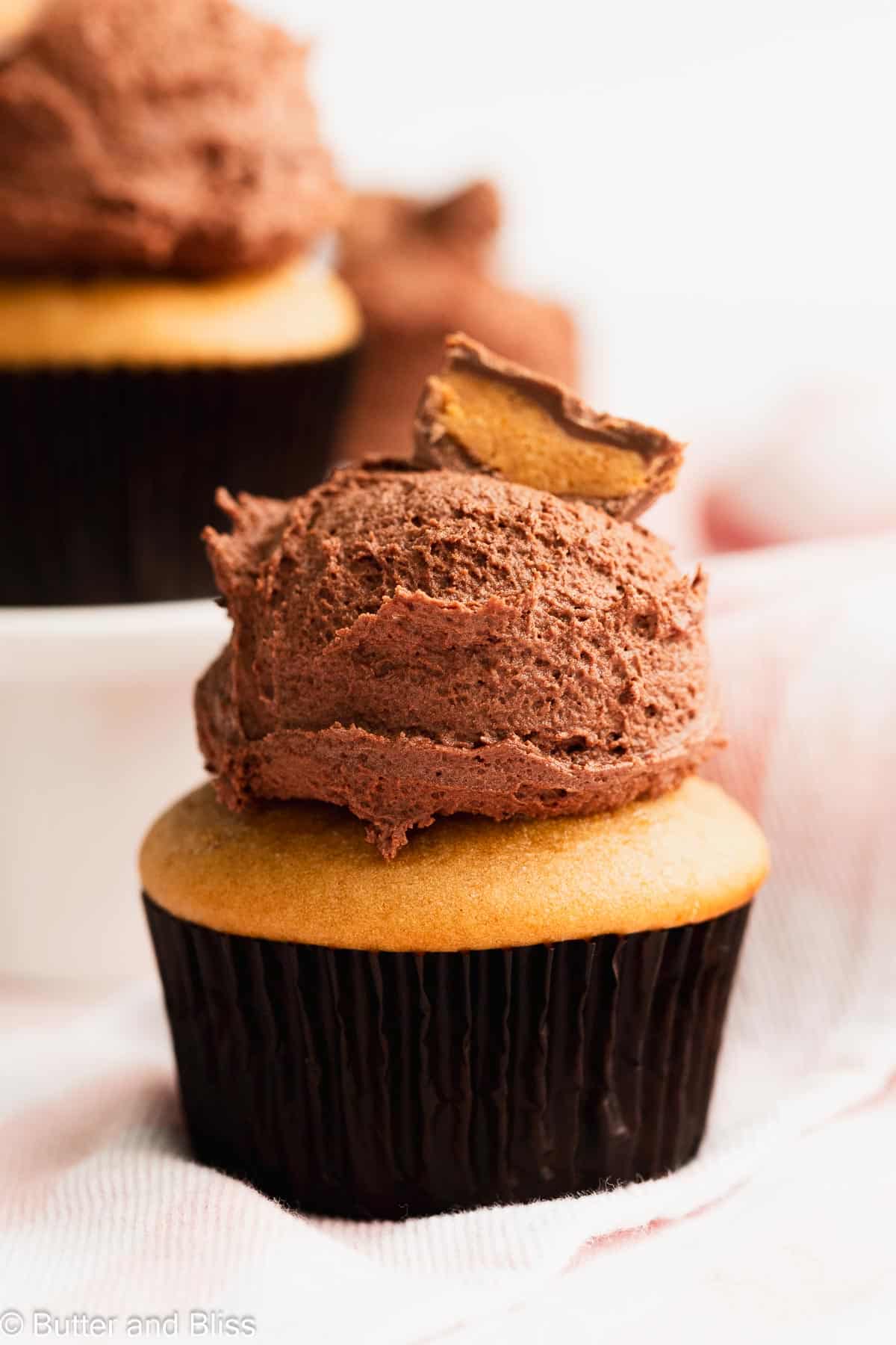 Scoop of chocolate peanut butter buttercream frosting on top of a cupcake.