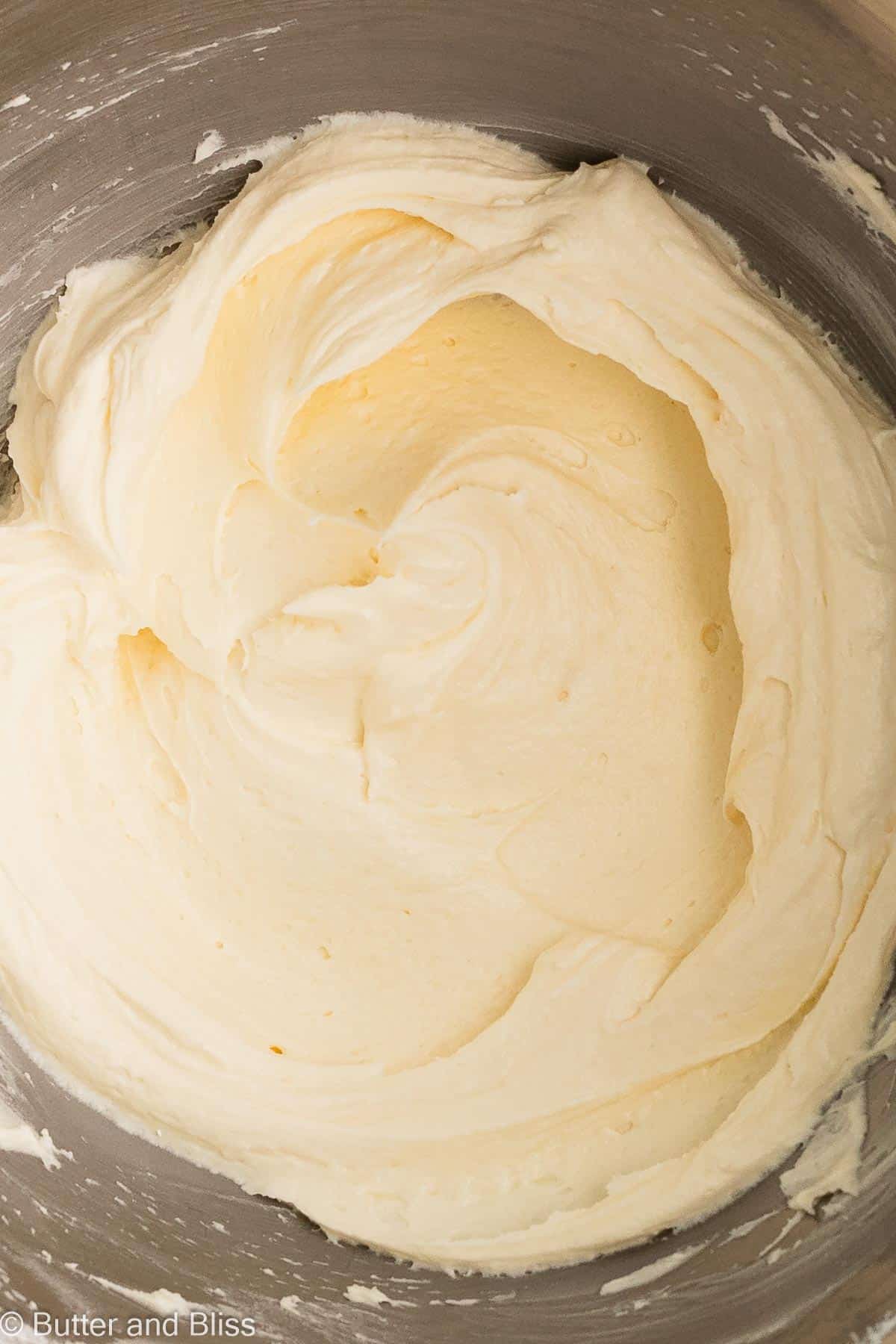 Velvety swirls of buttercream frosting in a mixing bowl.