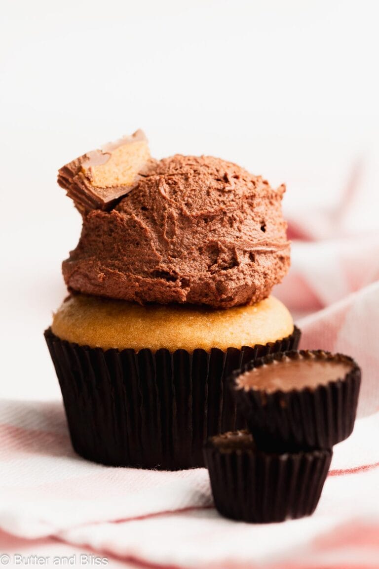 Peanut butter cupcake with chocolate frosting and topped with peanut butter candy.