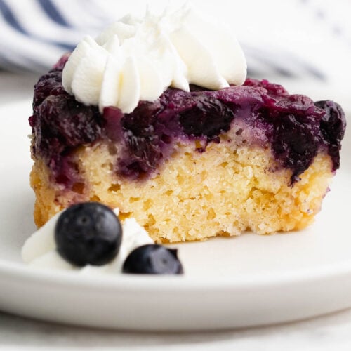 Perfect slice of buttery lemon blueberry upside down cake on a white plate.