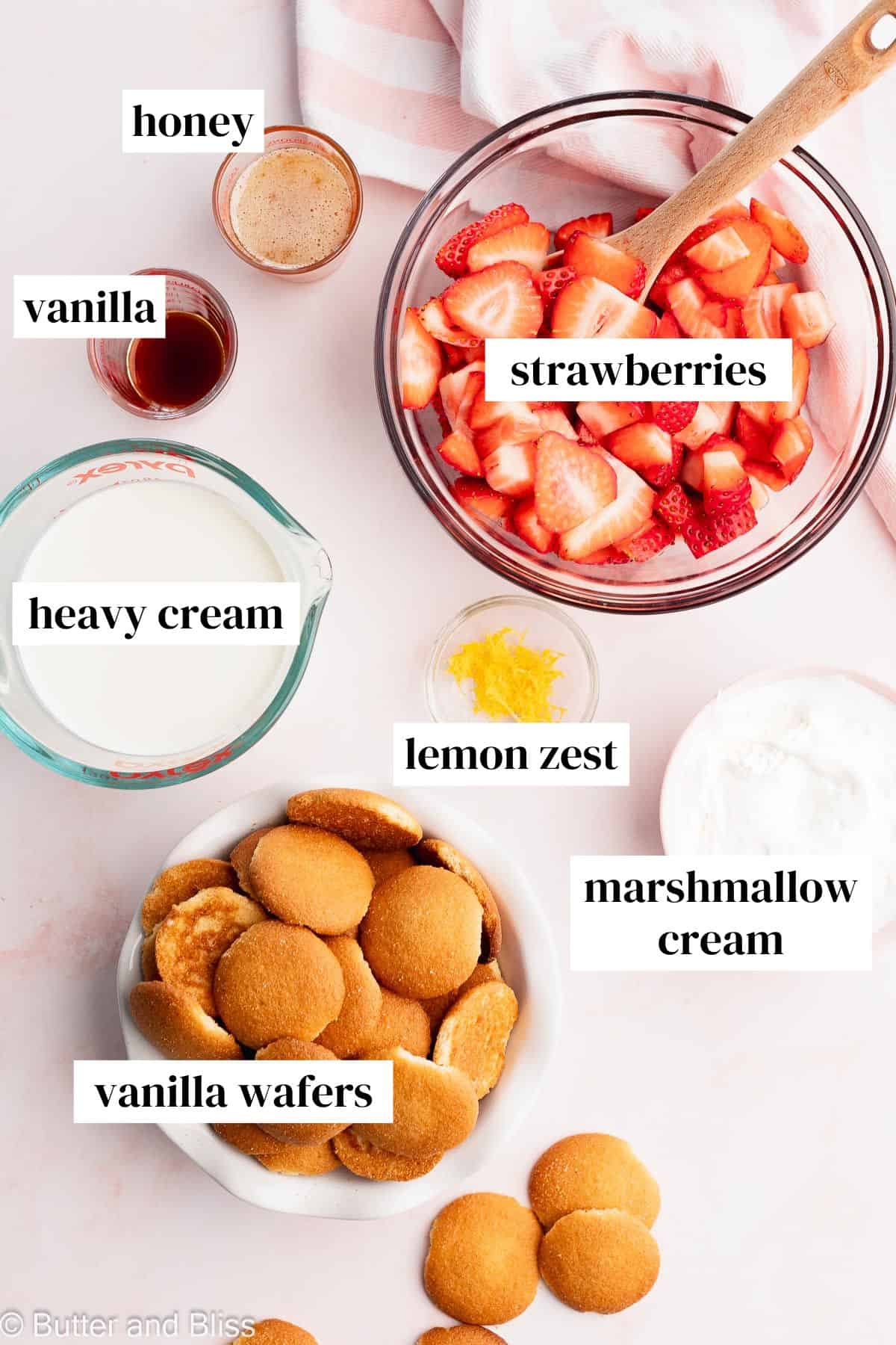Ingredients for no-bake summer strawberry cake in bowls on a table.