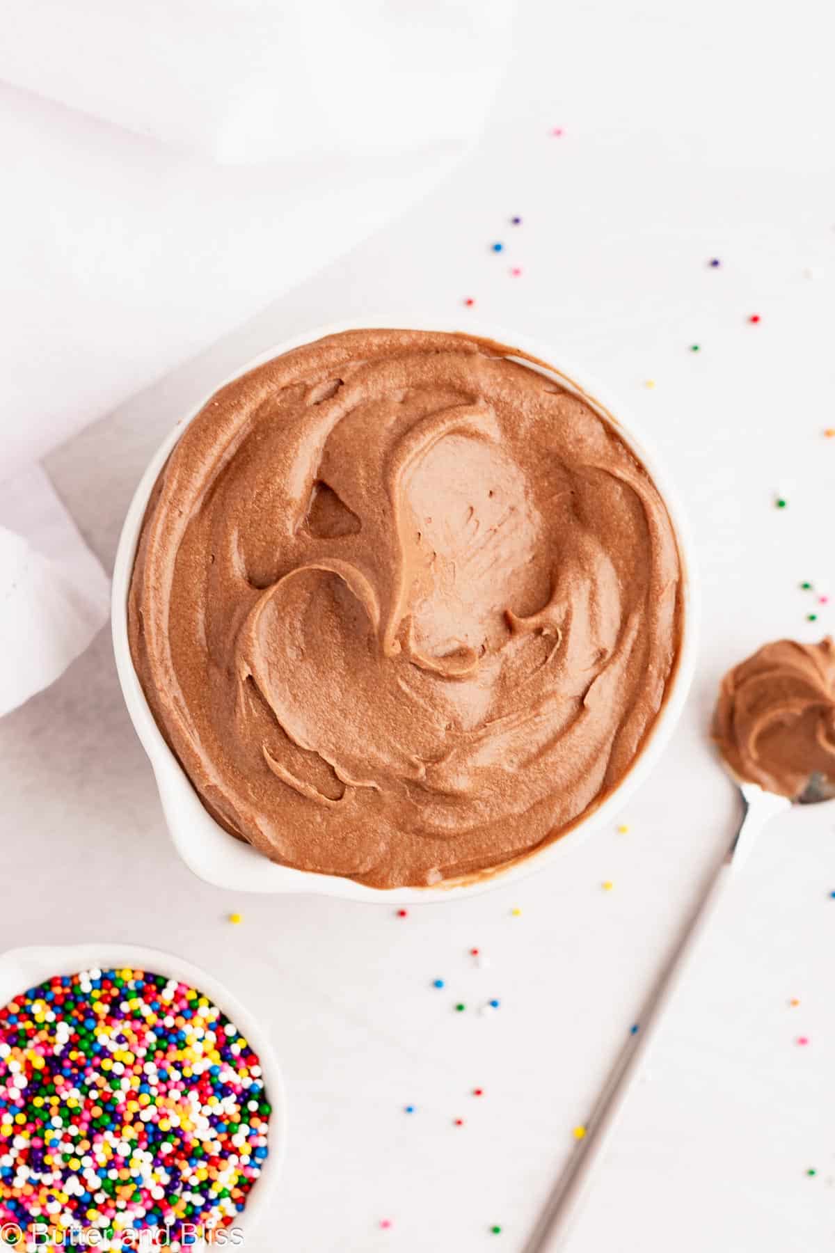 A small bowl filled with swirls of chocolate frosting without butter.