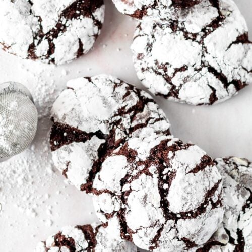 Fudgy chocolate crinkle cookies arranges on a table.