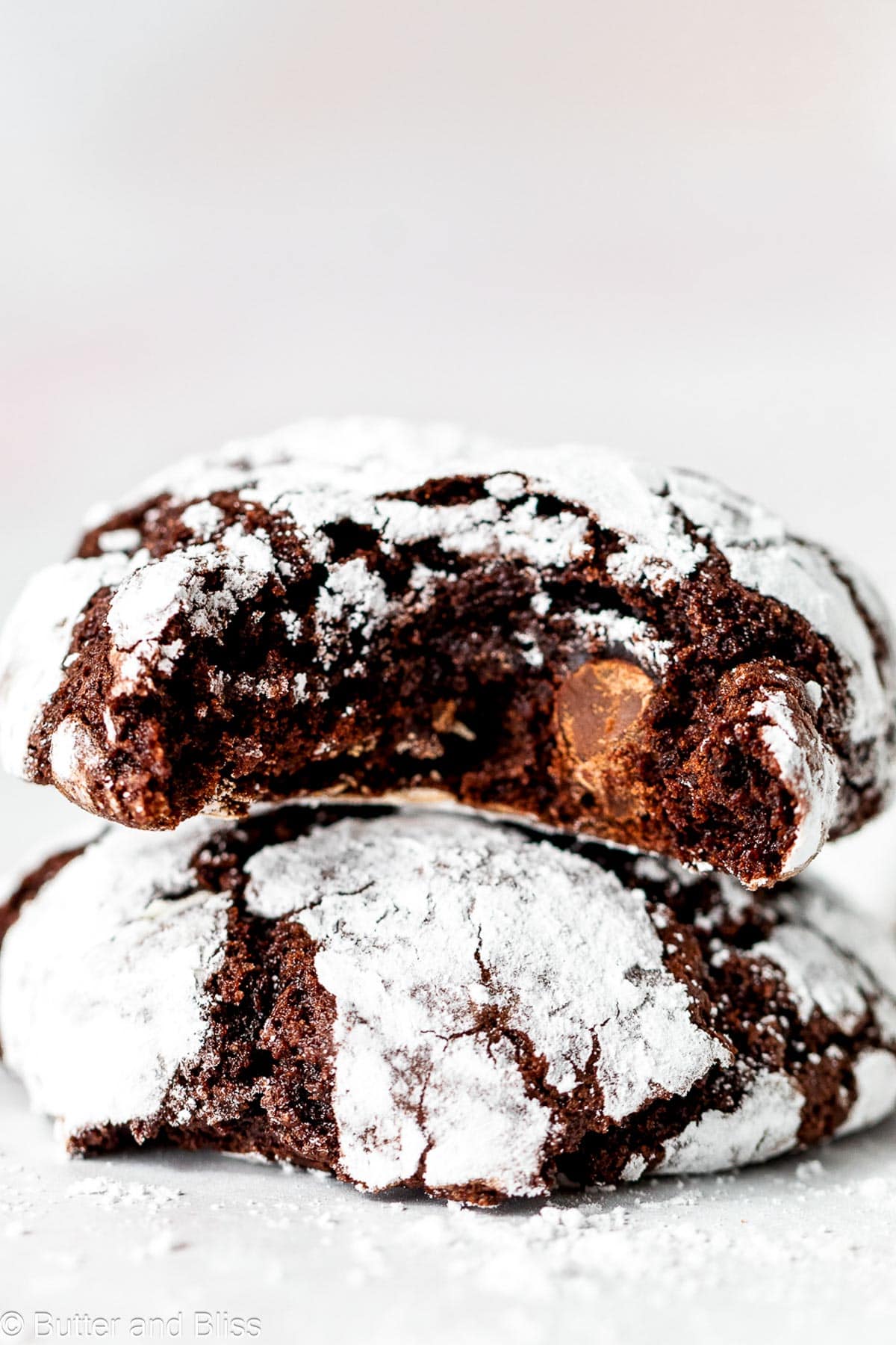 Two fudgy chocolate crinkle cookies in a stack.