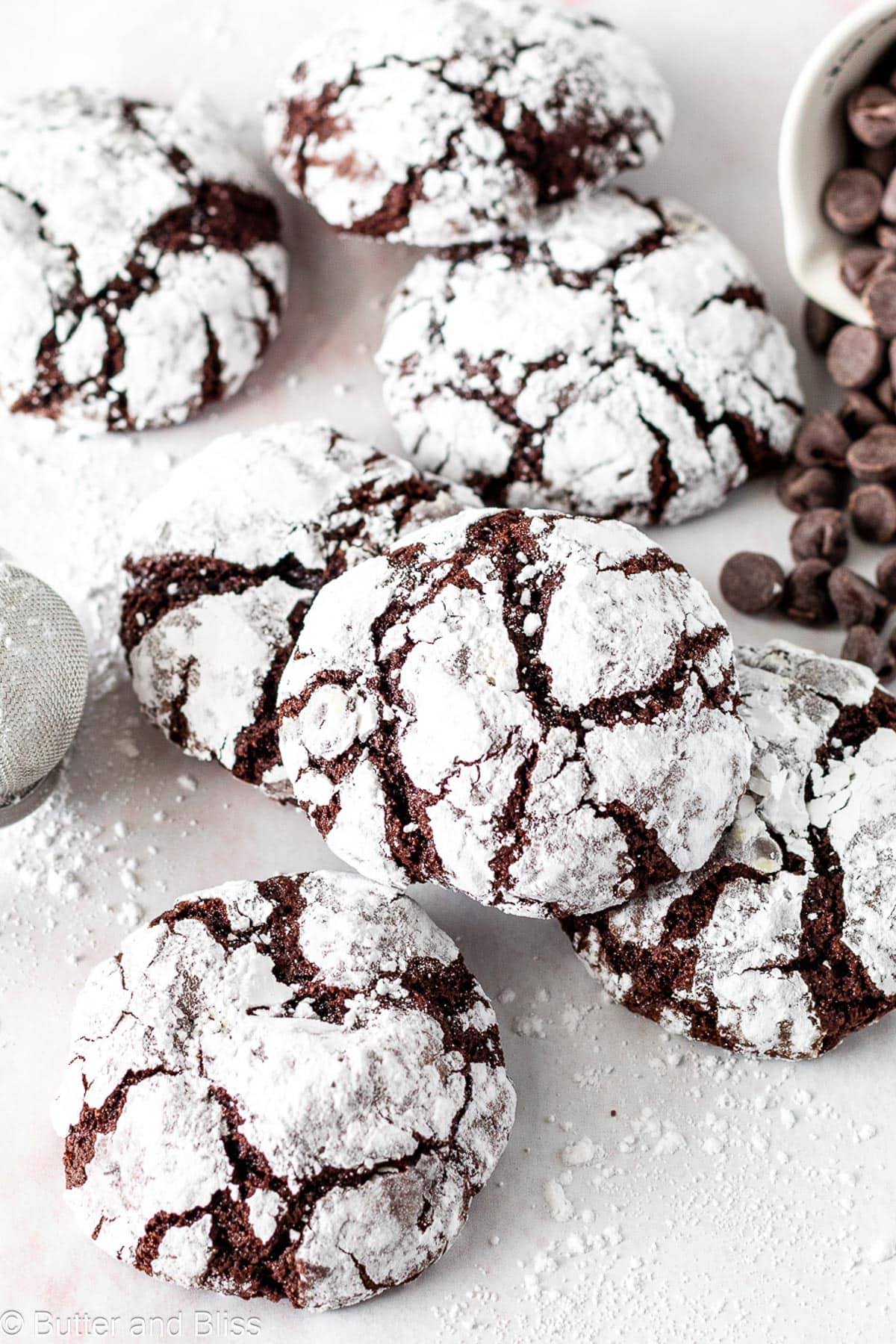 Small batch of chocolate crinkle cookies scattered on a table.