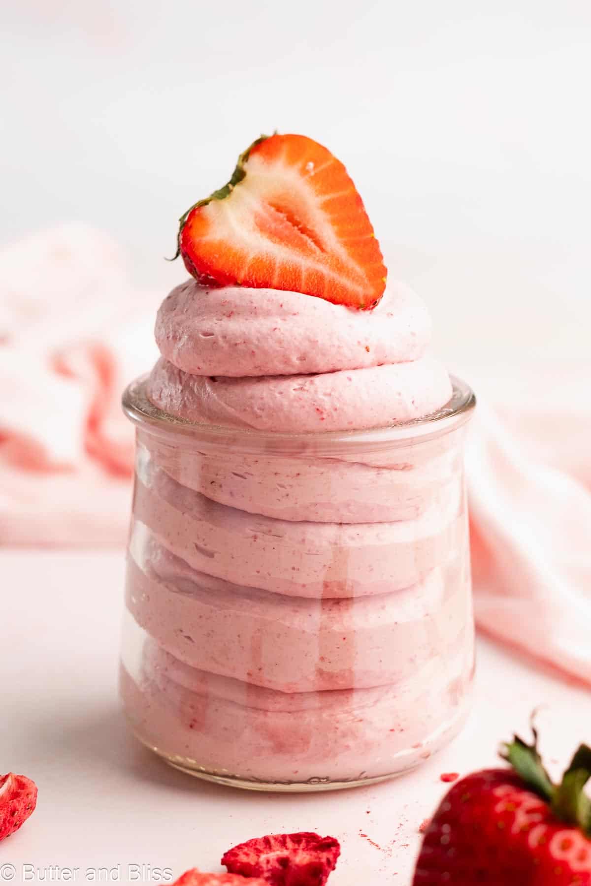 Whipped coconut cream with strawberry swirled in a jar.