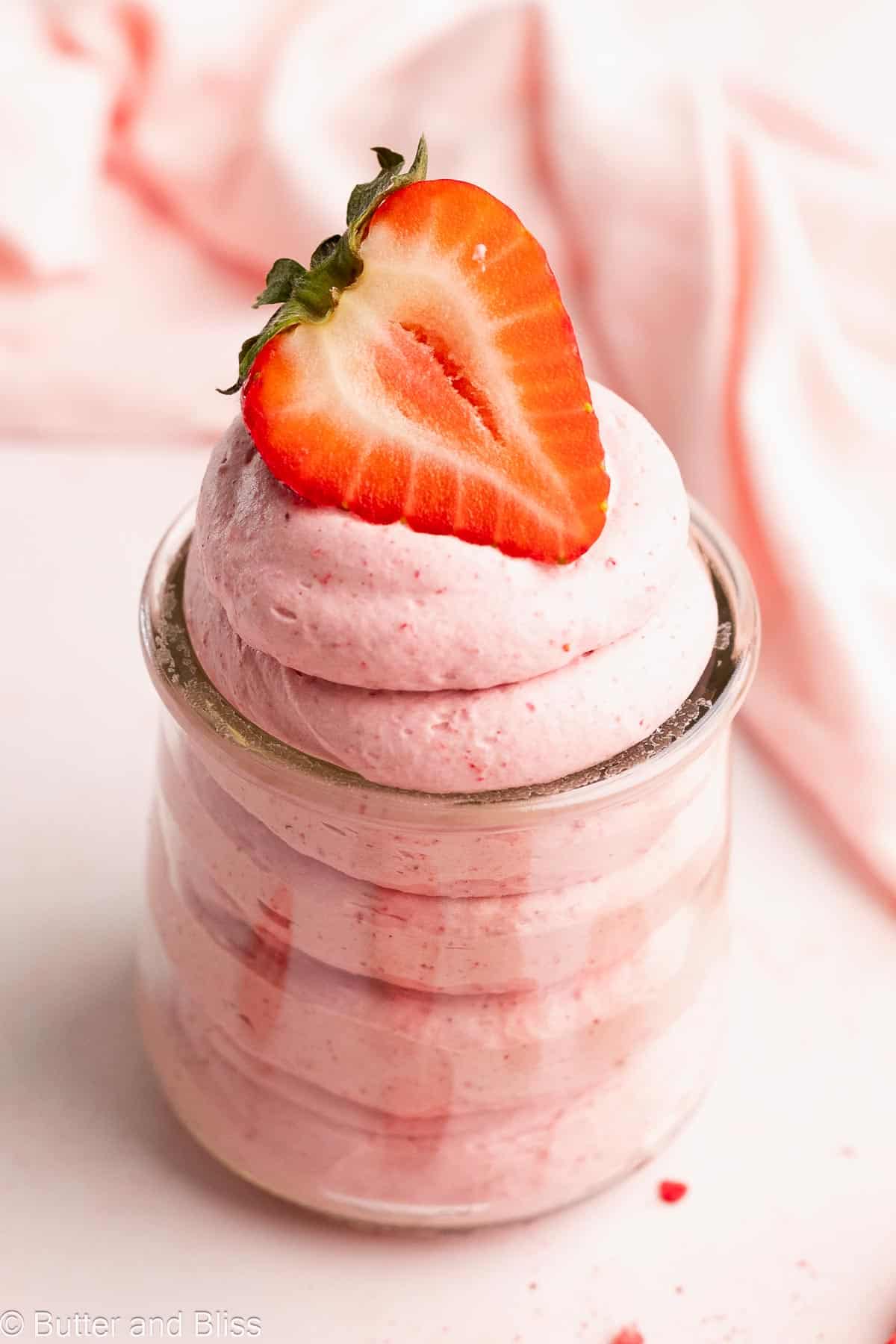 Creamy strawberry whipped coconut cream in a small jar with strawberry garnish.