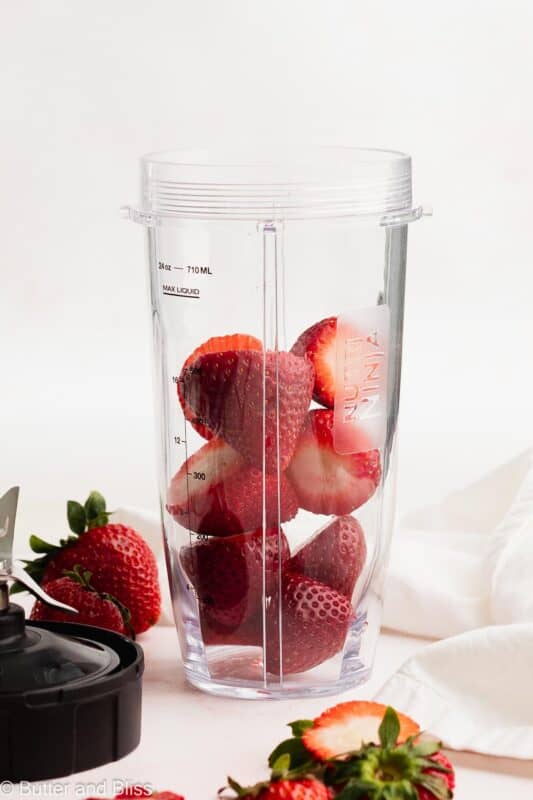 Fresh strawberries in a small blender.