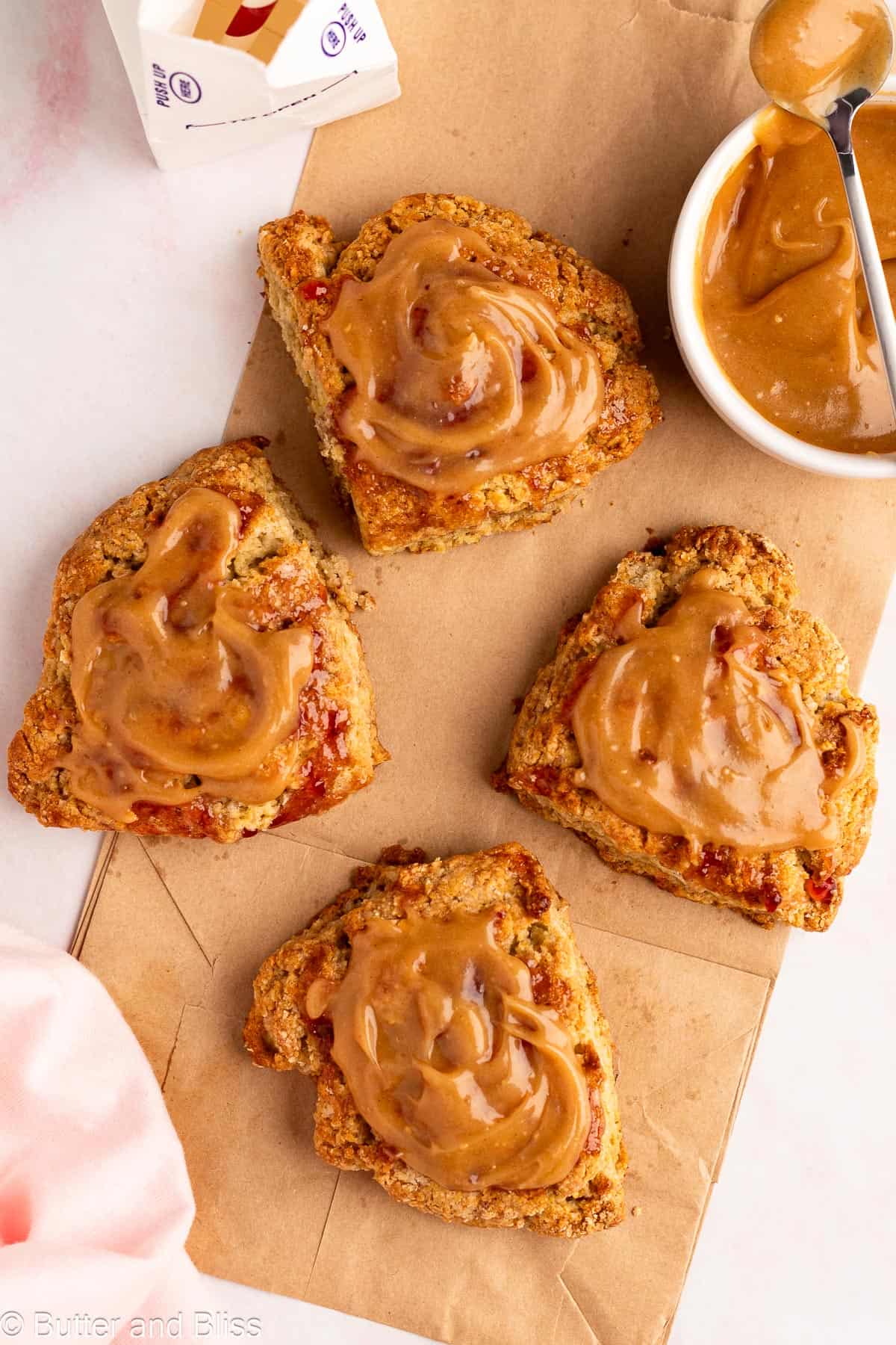 Small batch of jam and peanut butter scones on a paper bag.