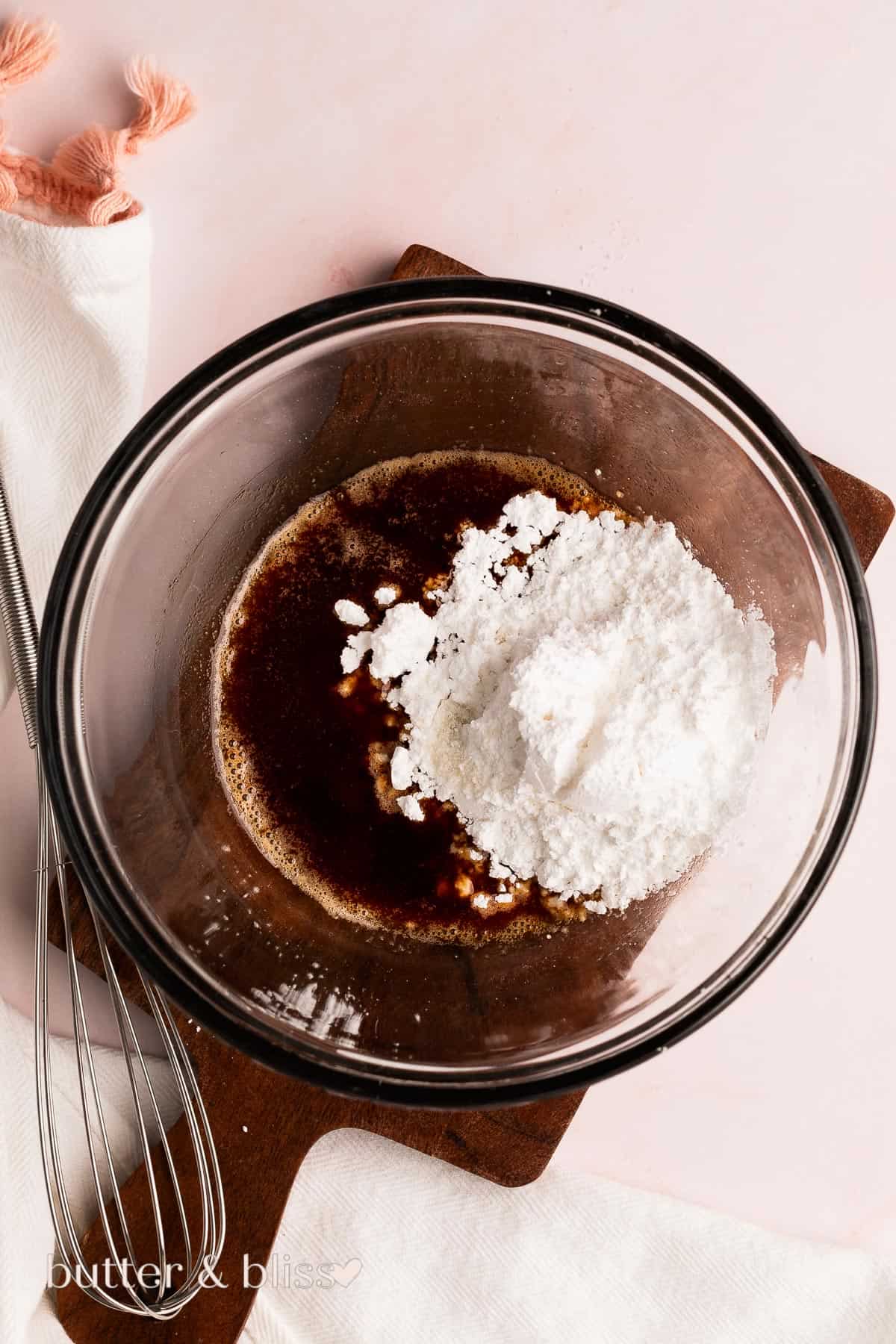 Powdered sugar added to mixing bowl full of heated butter.