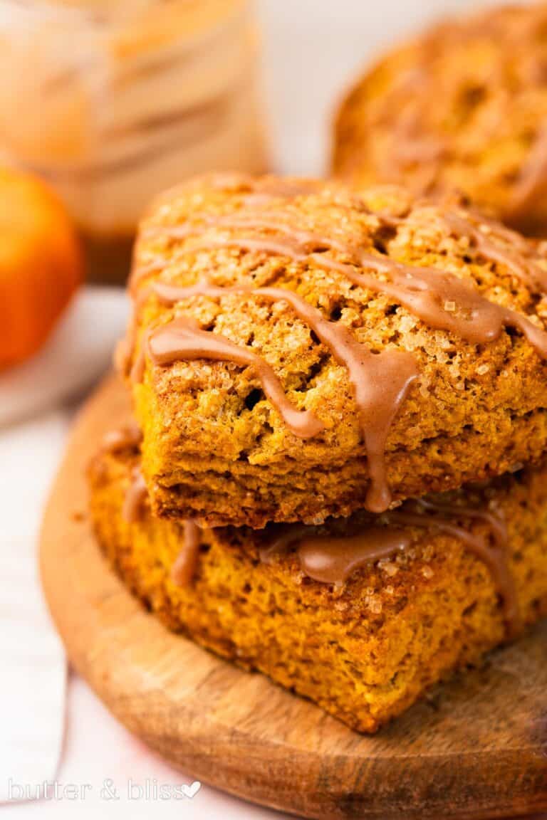 Two pumpkin scones stacked and drizzled with brown butter cinnamon glaze.