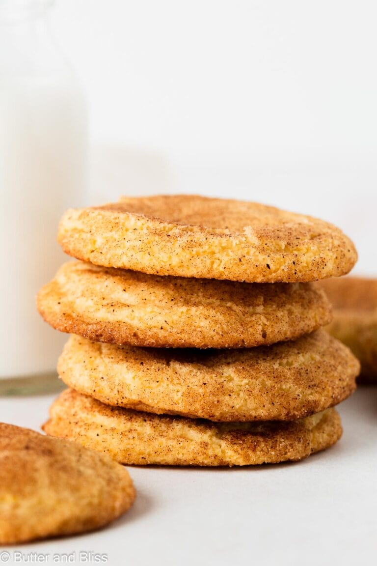 Stack of snickerdoodle cookies next to a glass of milk.