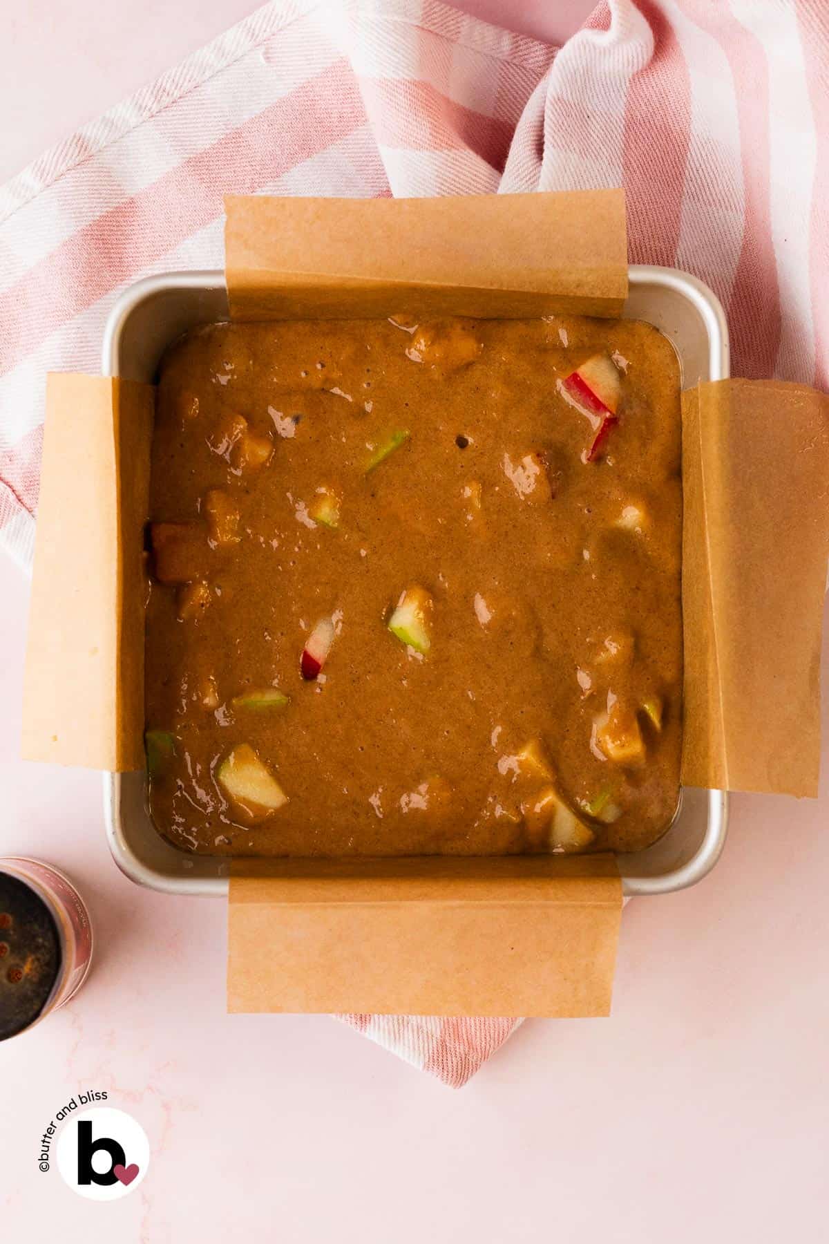 Apple spice cake batter in a prepared cake pan.