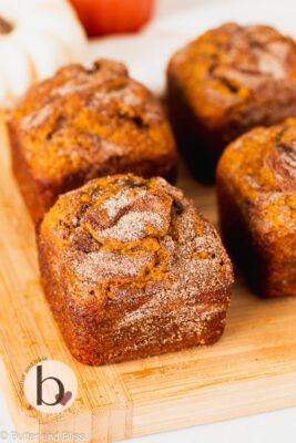 Small batch cinnamon swirl pumpkin bread loaves on a wood cutting board.