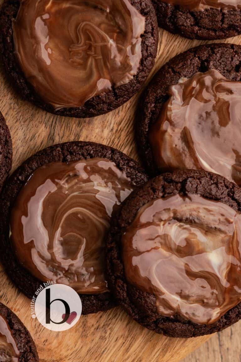 Chocolate cookies topped with melted Andes mint on a wood tray.