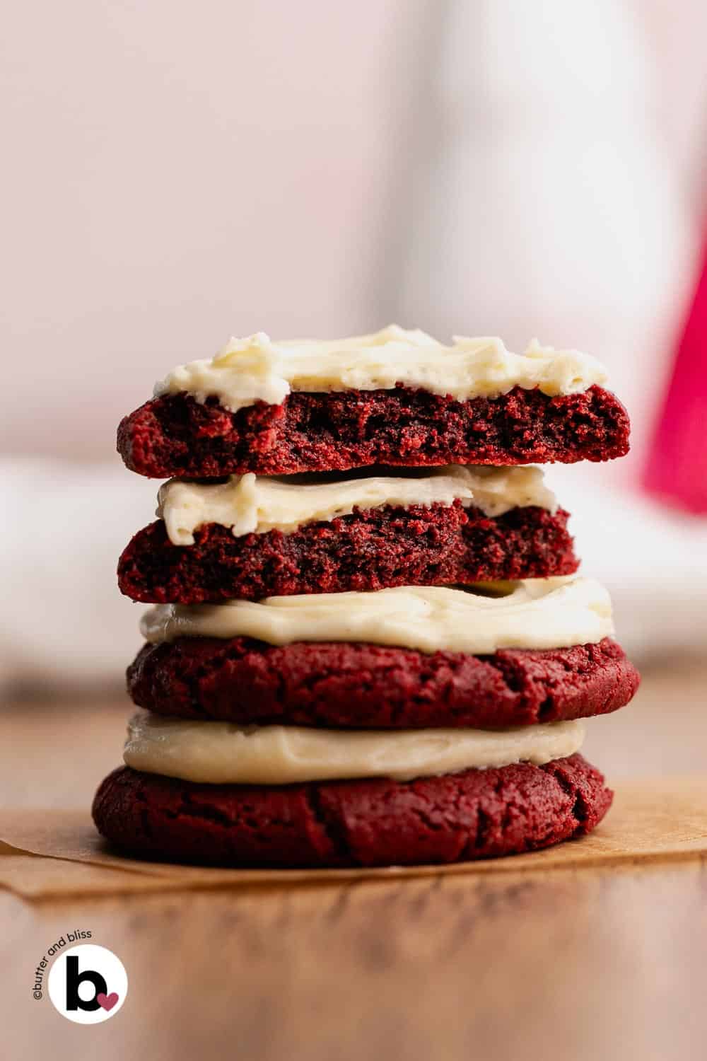 Fudgy inside of a red velvet cooki cut in half and stacked on more cookies.