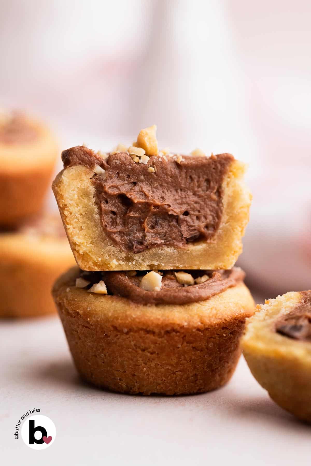 A stack of two chocolate filled brown sugar cookie cups on a table.