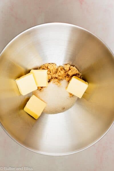 Butter in a mixing bowl with sugars, ready to be mixed.