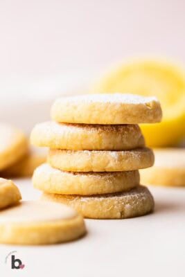 Stack of lemon shortbread cookies dusted with powdered sugar.