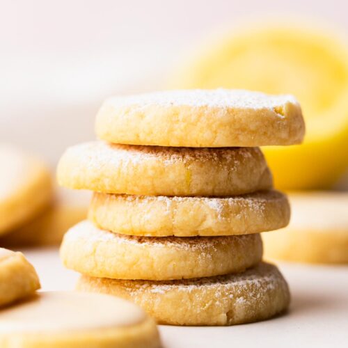 Stack of lemon shortbread cookies dusted with powdered sugar.