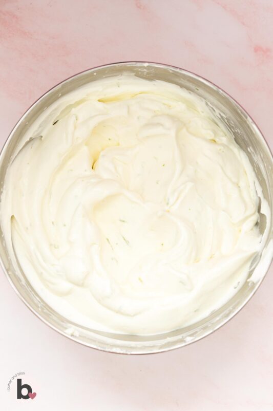 Fluffy lime whipped cream in a mixing bowl.