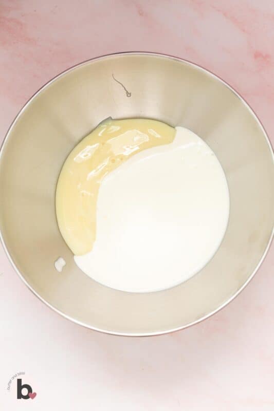 Heavy cream and condensed milk in a mixing bowl.