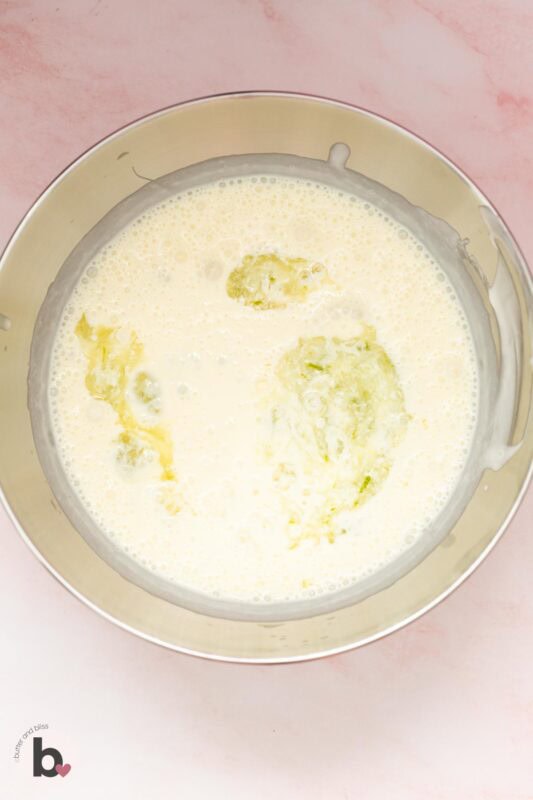 Lime juice and zest added to a mixing bowl of whipped cream.