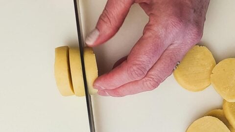 Shortbread dough sliced into rounds.