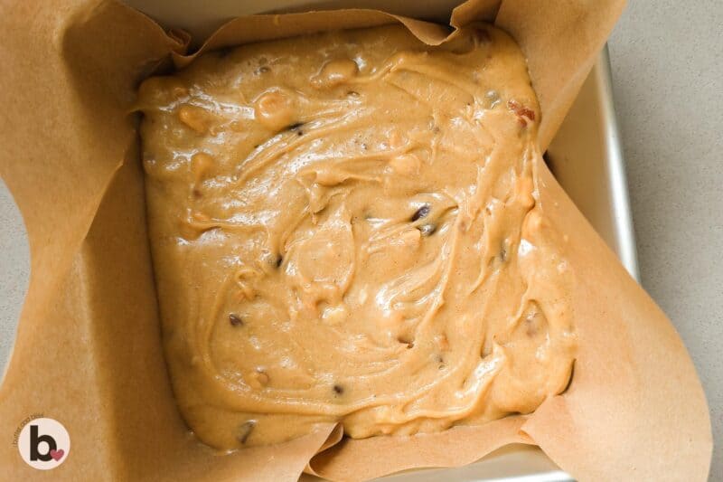 Small batch of blondies dough pressed into a small cake pan.