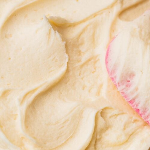 Super creamy vanilla buttercream frosting spread on a cake.
