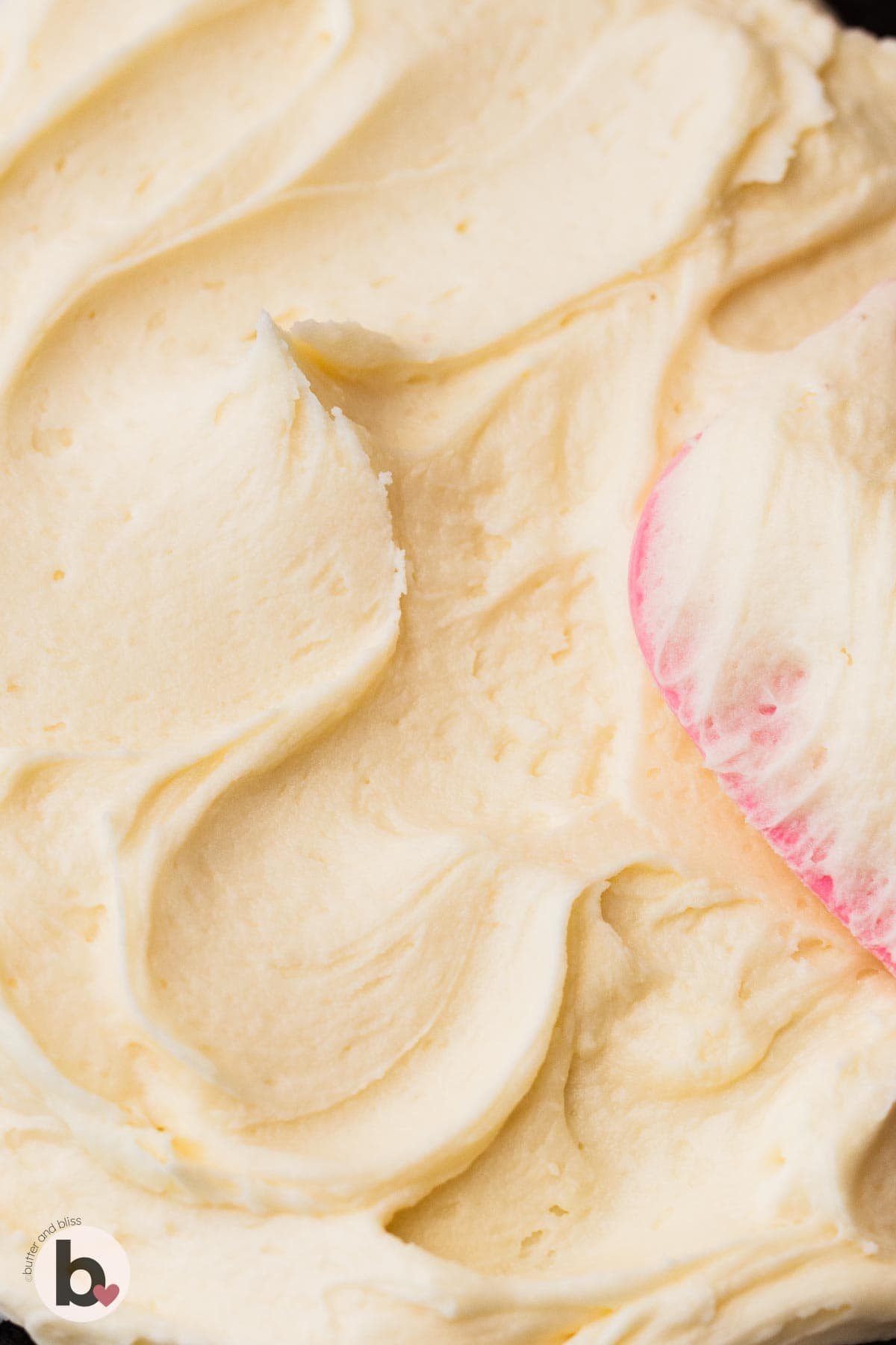 Super creamy vanilla buttercream frosting spread on a cake.