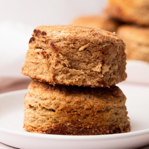 Two cinnamon sugar biscuits stacked on a white plate.