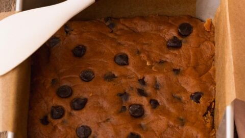 Chocolate chip pumpkin bars pressed into a baking pan.