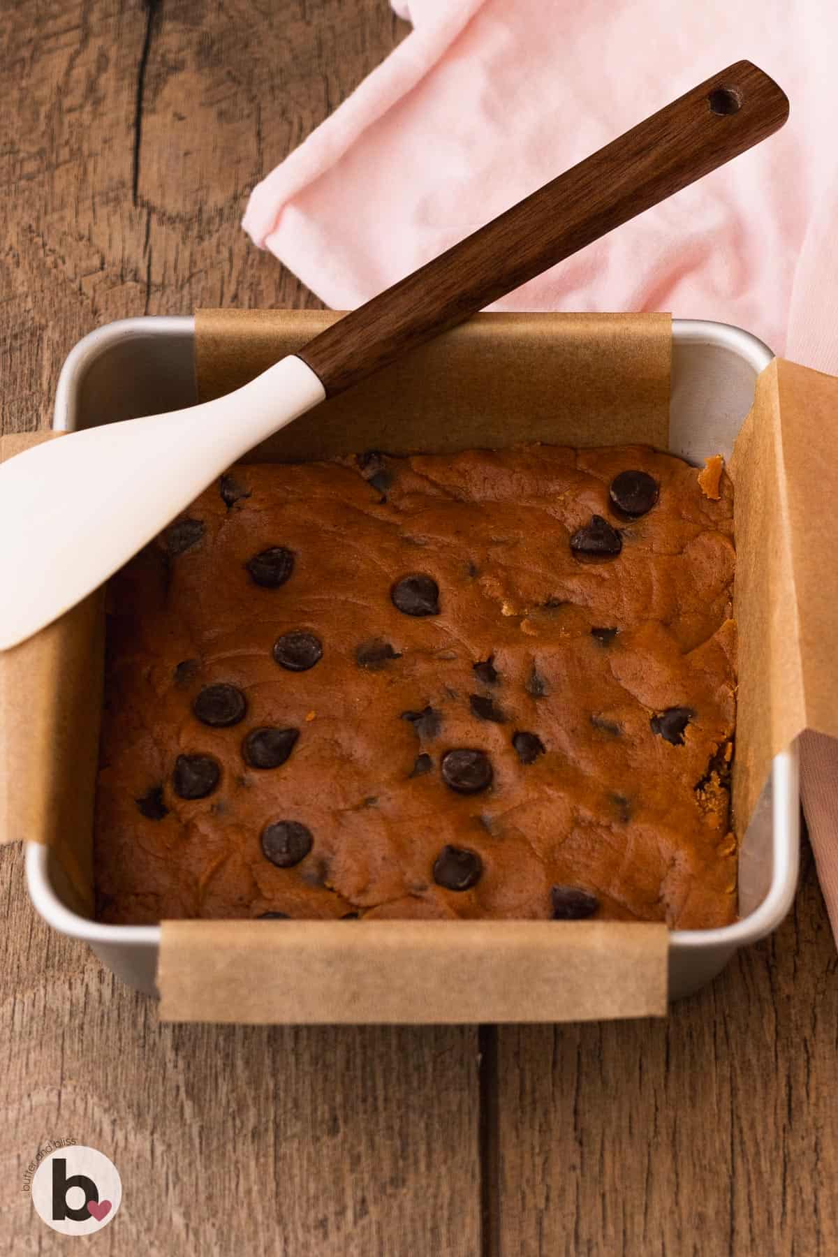 Chocolate chip pumpkin bars pressed into a baking pan.