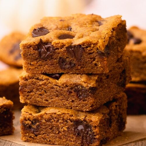 A stack of three thick and chewy chocolate chip pumpkin bars.