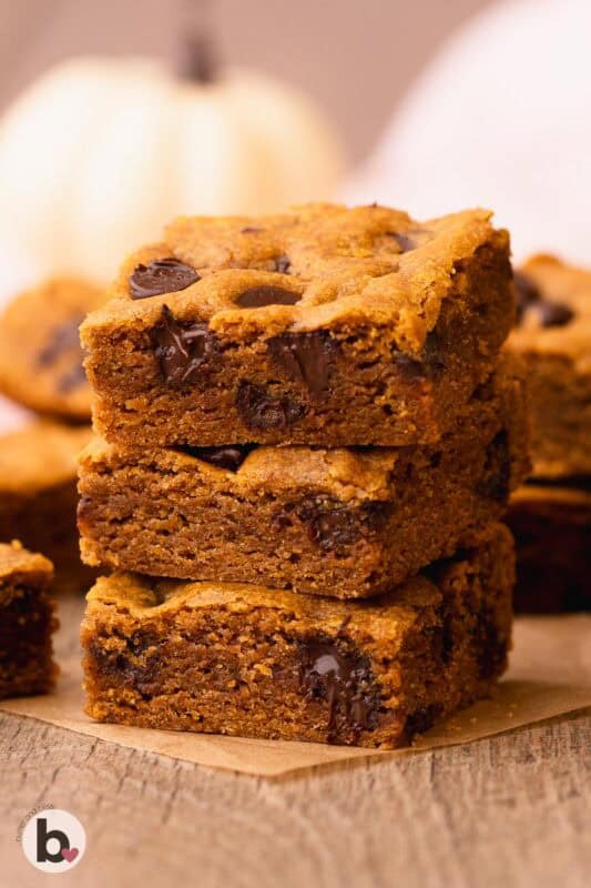 A stack of three thick and chewy chocolate chip pumpkin bars.