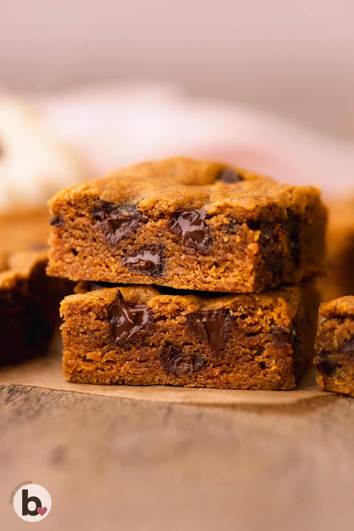 A stack of two pumpkin chocolate chip cookie bars on a wood tray.