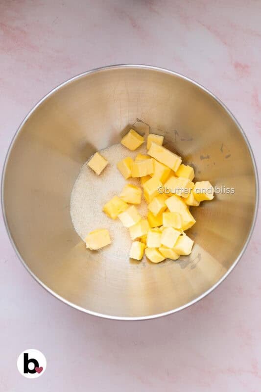 Sugar and butter cubes in a mixing bowl.