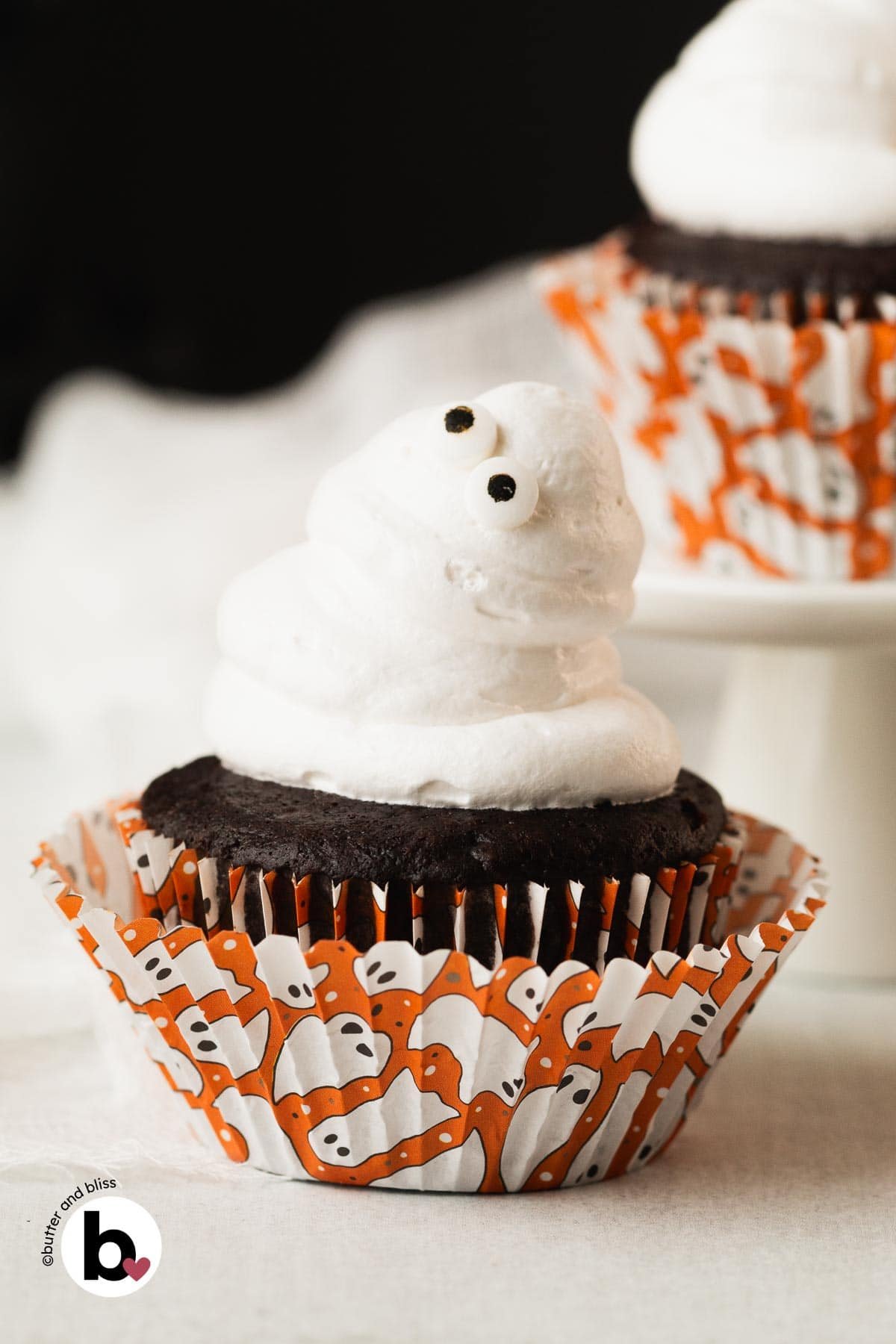 Single chocolate Halloween cupcake decorated with a fluffy marshmallow frosting ghost.