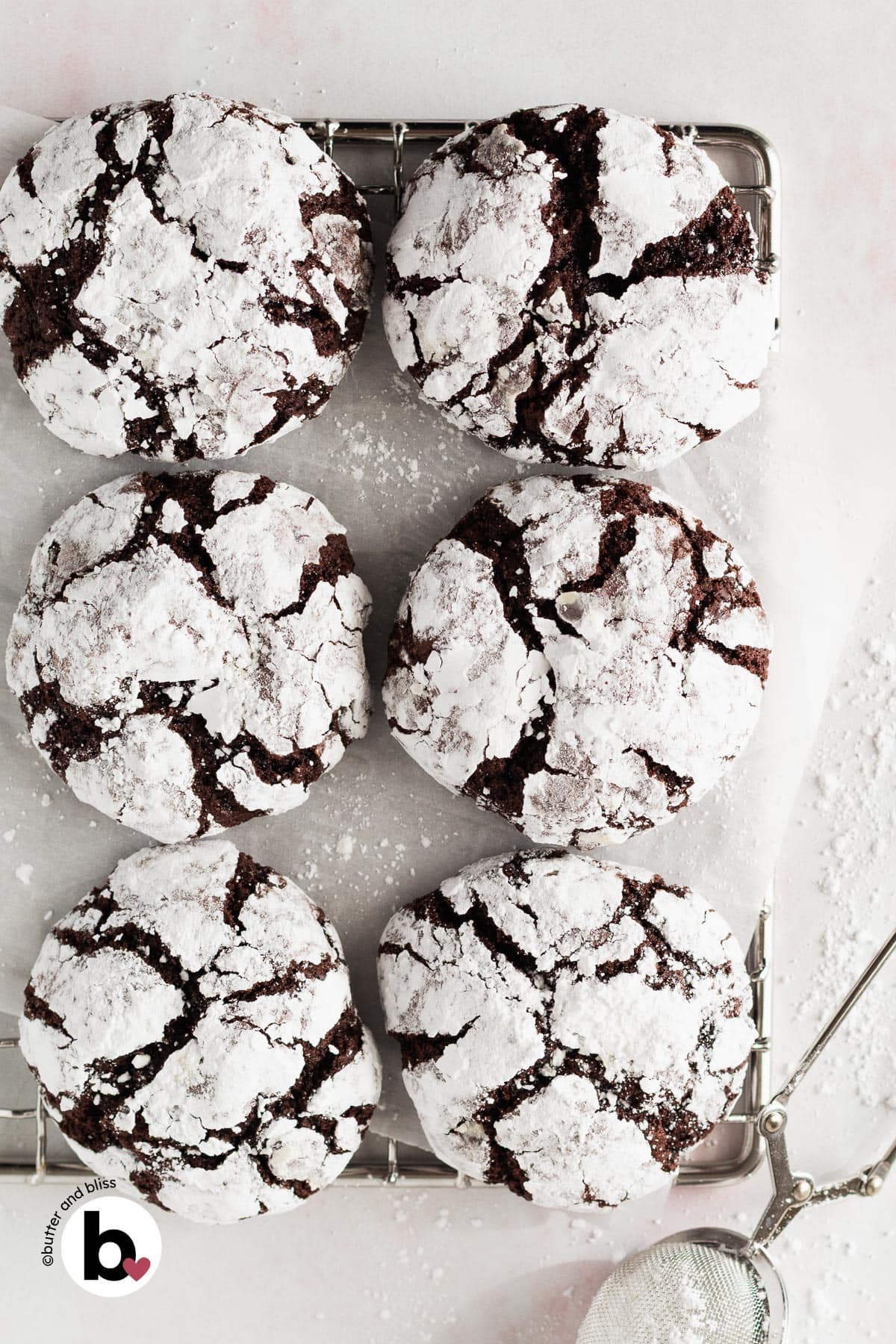 Small batch of chocolate crinkle cookies lined up on a wire cooling rack.