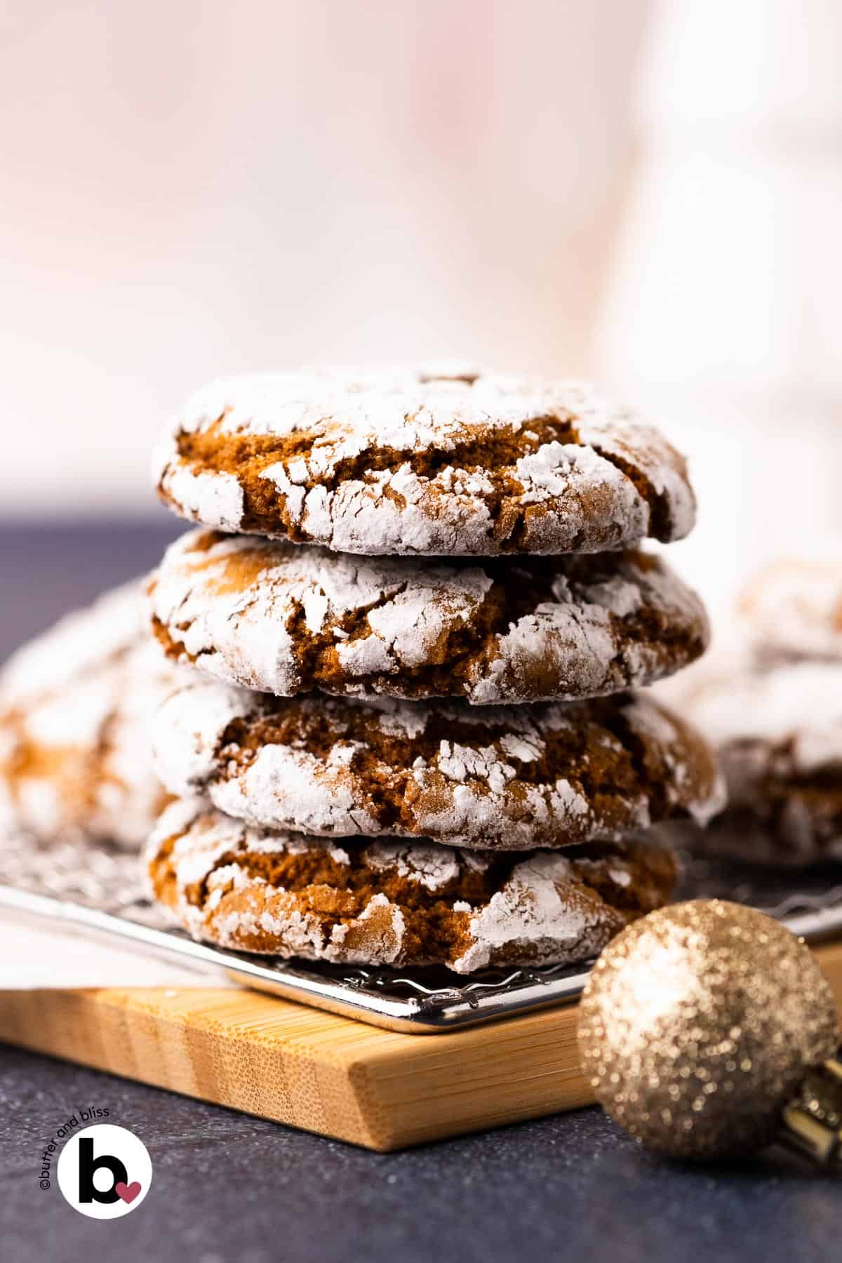 A stack of chewy molasses crinkle cookes on a wood plate.