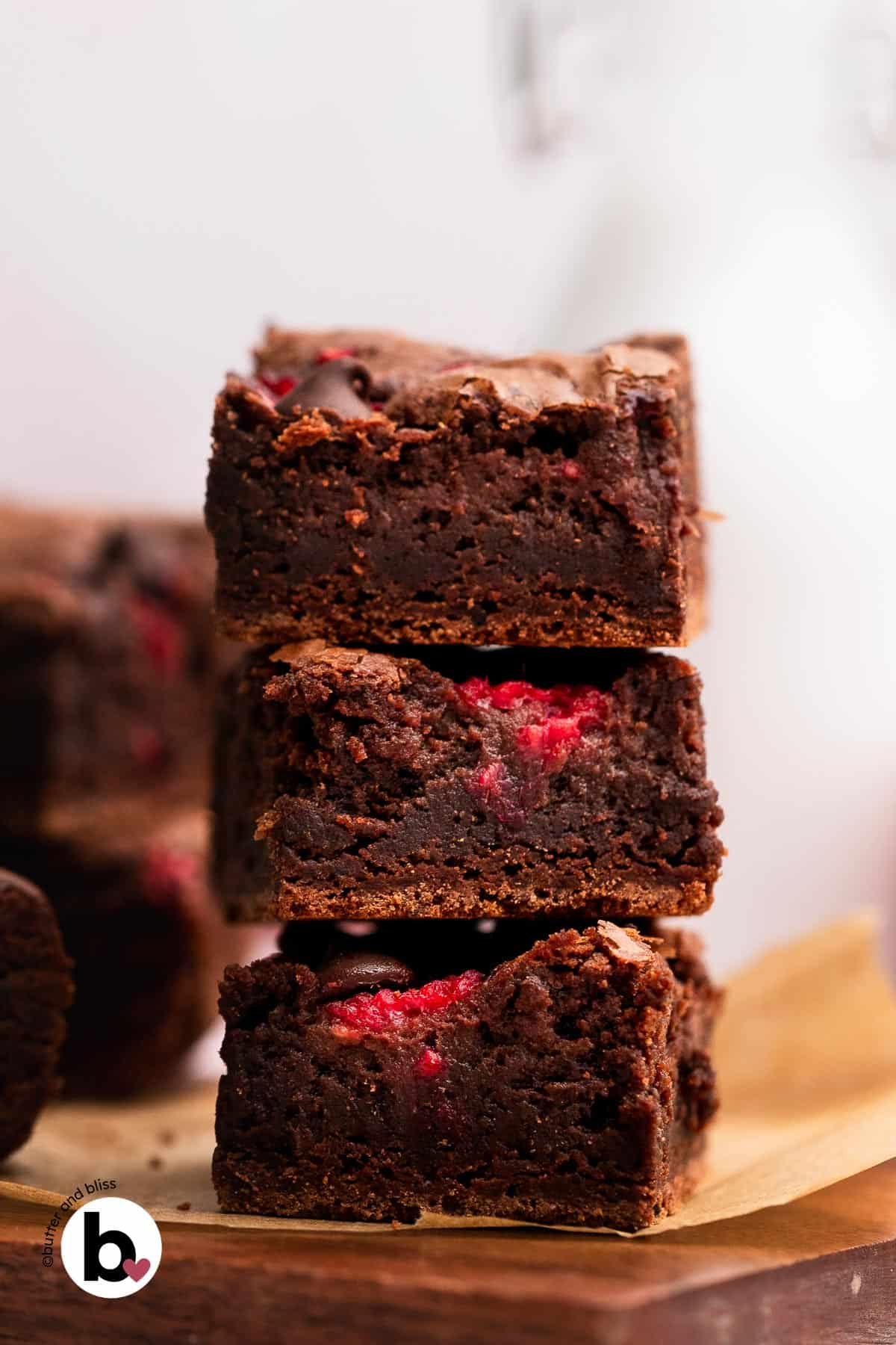 Three fudgy raspberry brownies in a stack.