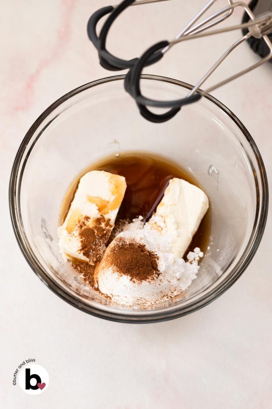 Cream cheese and maple syrup in a mixing bowl.