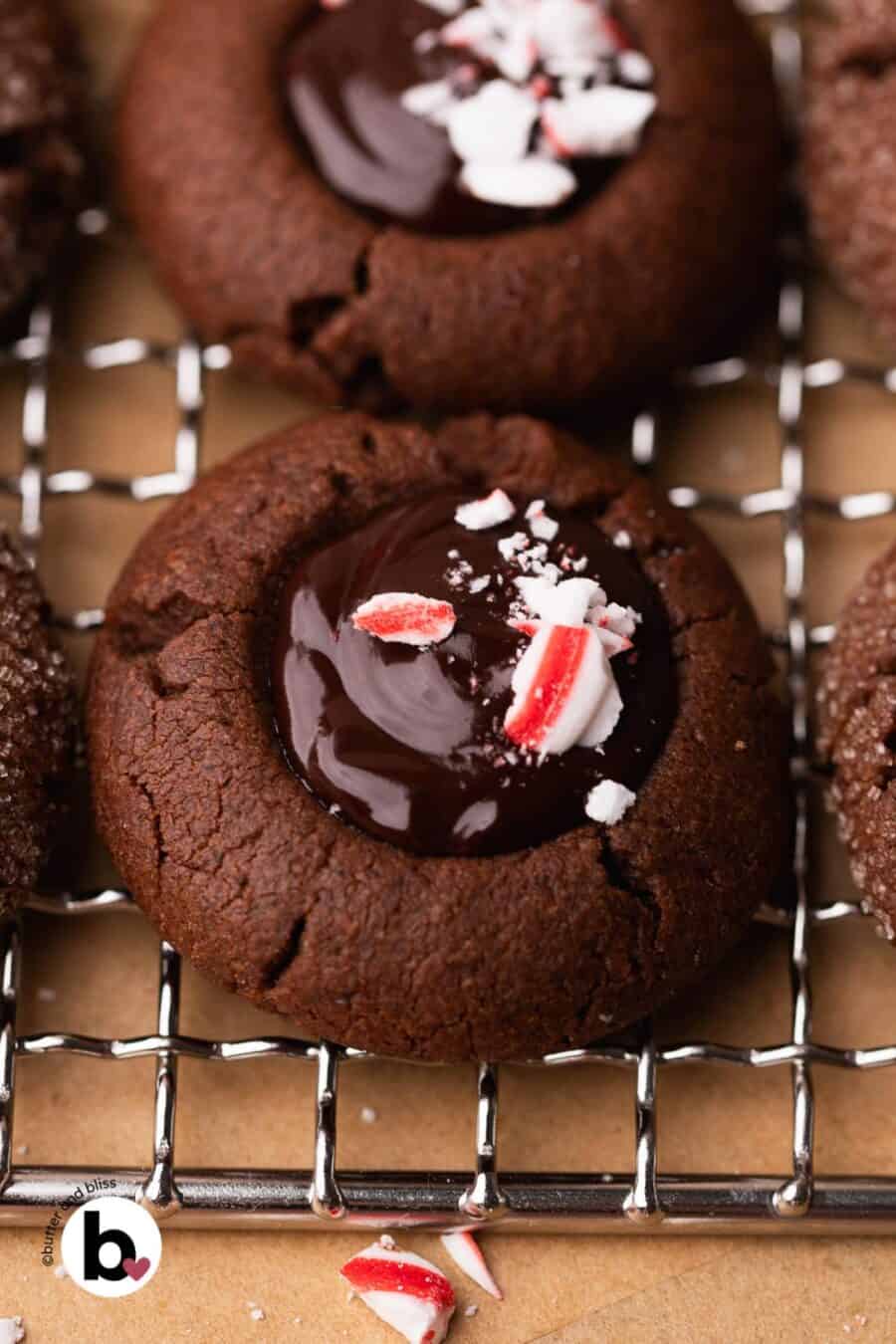 Chocolate peppermint thumbprint cookie filled with glossy ganache and topped with peppermint candies.